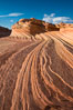 The Second Wave at sunset. The Second Wave, a curiously-shaped sandstone swirl, takes on rich warm tones and dramatic shadowed textures at sunset. Set in the North Coyote Buttes of Arizona and Utah, the Second Wave is characterized by striations revealing layers of sedimentary deposits, a visible historical record depicting eons of submarine geology. Paria Canyon-Vermilion Cliffs Wilderness, USA. Image #28619