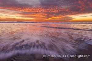 Sunset and incoming surf, gorgeous colors in the sky and on the ocean at dusk, the incoming waves are blurred in this long exposure, Carlsbad, California