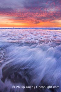 Sunset and incoming surf, gorgeous colors in the sky and on the ocean at dusk, the incoming waves are blurred in this long exposure, Carlsbad, California