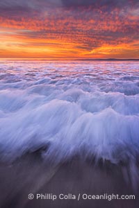 Sunset and incoming surf, gorgeous colors in the sky and on the ocean at dusk, the incoming waves are blurred in this long exposure, Carlsbad, California