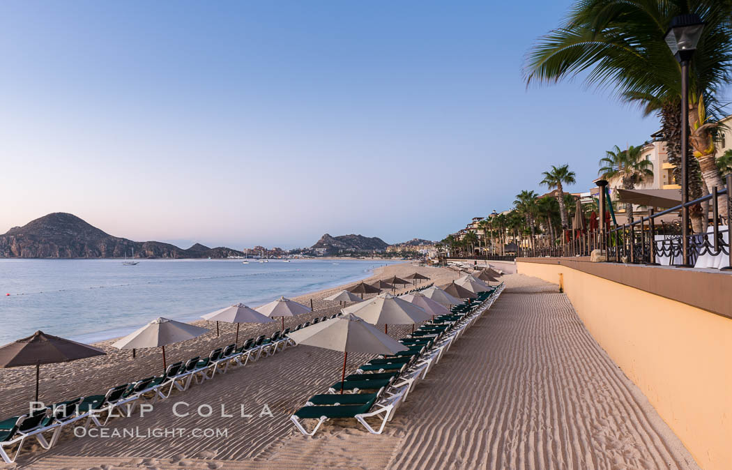 Beach chairs and umbrellas line the sand in front of resorts on Medano Beach, Cabo San Lucas, Mexico