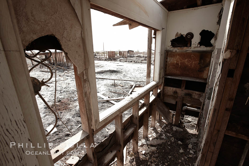 Bombay Beach, lies alongside and below the flood level of the Salton Sea, so that it floods occasionally when the Salton Sea rises.  A part of Bombay Beach is composed of derelict old trailer homes, shacks and wharfs, slowly sinking in the mud and salt, Imperial County, California