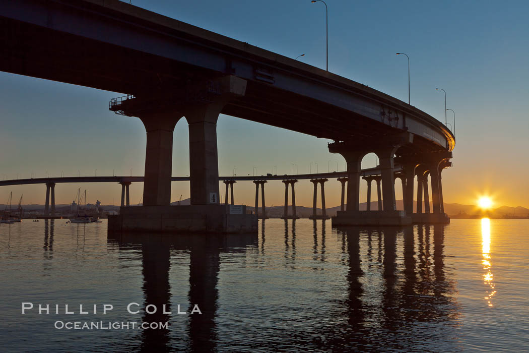 Coronado Bridge, linking San Diego to Coronado, sunrise, viewed from Coronado Island. San Diego Coronado Bridge, known locally as the Coronado Bridge, links San Diego with Coronado, California. The bridge was completed in 1969 and was a toll bridge until 2002. It is 2.1 miles long and reaches a height of 200 feet above San Diego Bay. USA, natural history stock photograph, photo id 27101