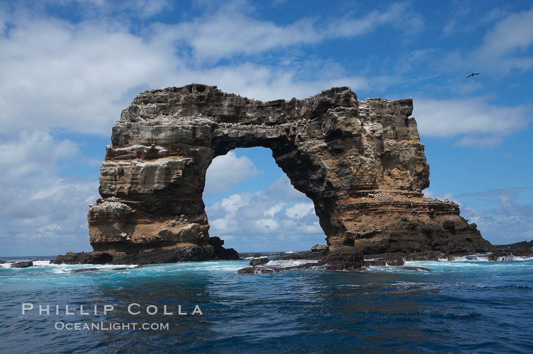 Darwins Arch, a dramatic 50-foot tall natural lava arch, rises above the ocean a short distance offshore of Darwin Island. Galapagos Islands, Ecuador, natural history stock photograph, photo id 16628
