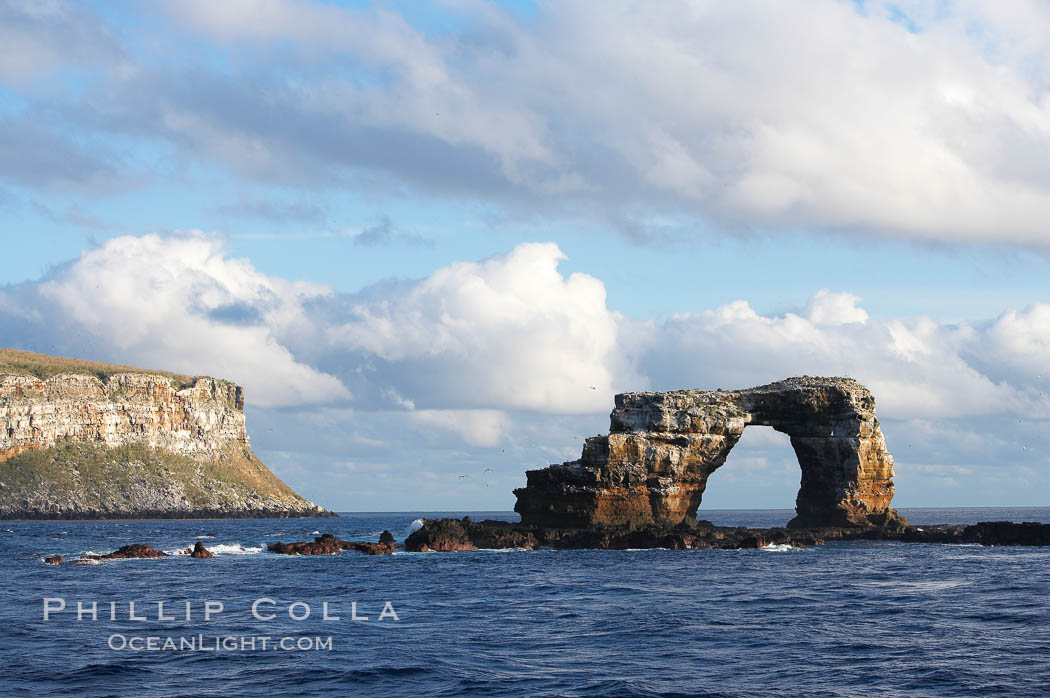 Darwins Arch, a dramatic 50-foot tall natural lava arch, rises above the ocean a short distance offshore of Darwin Island. Galapagos Islands, Ecuador, natural history stock photograph, photo id 16653