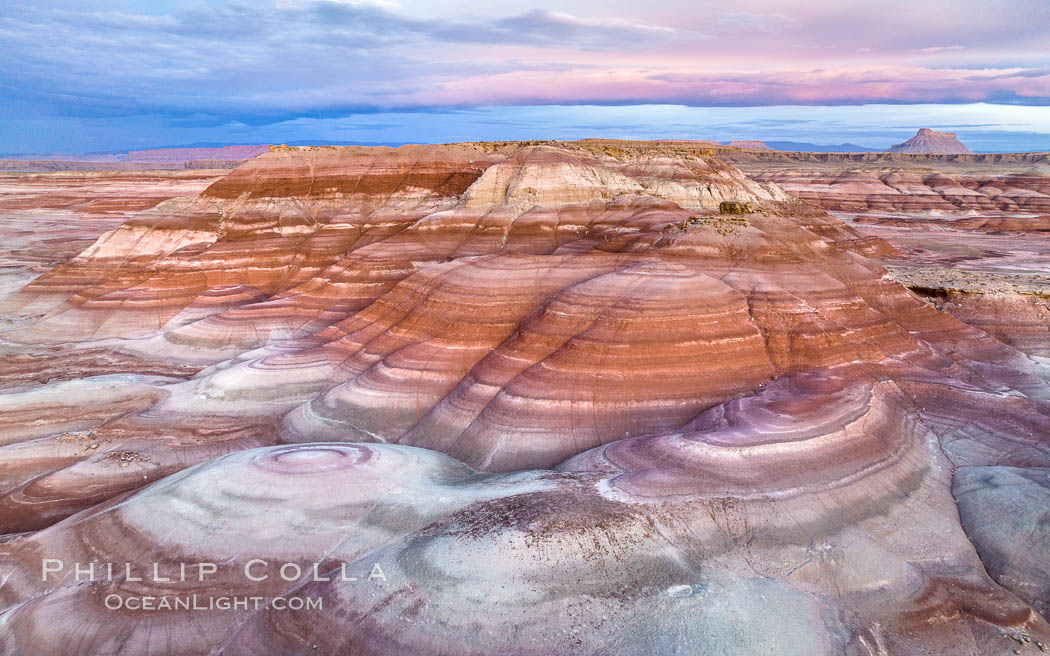 Dawn breaks over the Bentonite Hills in the Utah Badlands.  Striations in soil reveal layers of the Morrison Formation, formed in swamps and lakes in the Jurassic era. Aerial panoramic photograph. USA, natural history stock photograph, photo id 38062