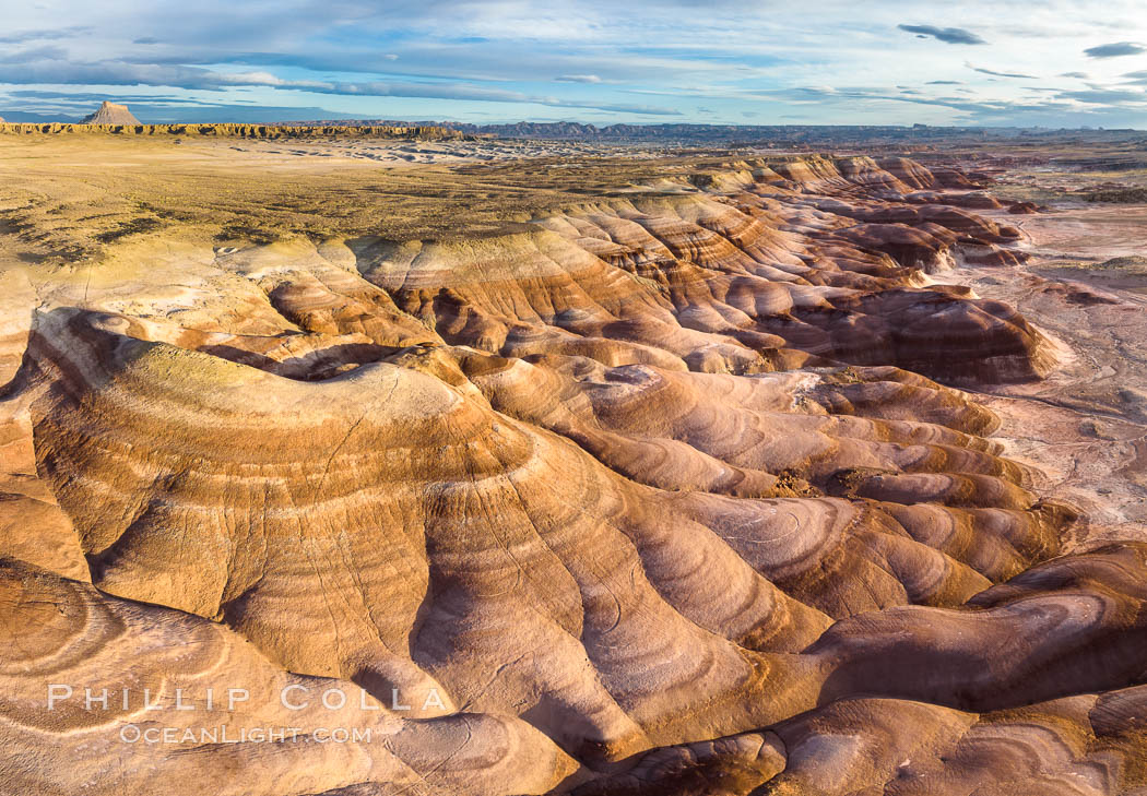 Dawn breaks over the Bentonite Hills in the Utah Badlands.  Striations in soil reveal layers of the Morrison Formation, formed in swamps and lakes in the Jurassic era. Aerial panoramic photograph. USA, natural history stock photograph, photo id 38065