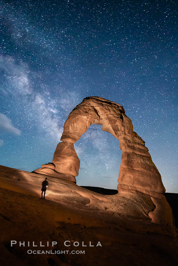 Delicate Arch and Milky Way, lit by quarter moon, hiker's flashlight and the fading blue sky one hour after sunset. Arches National Park, Utah