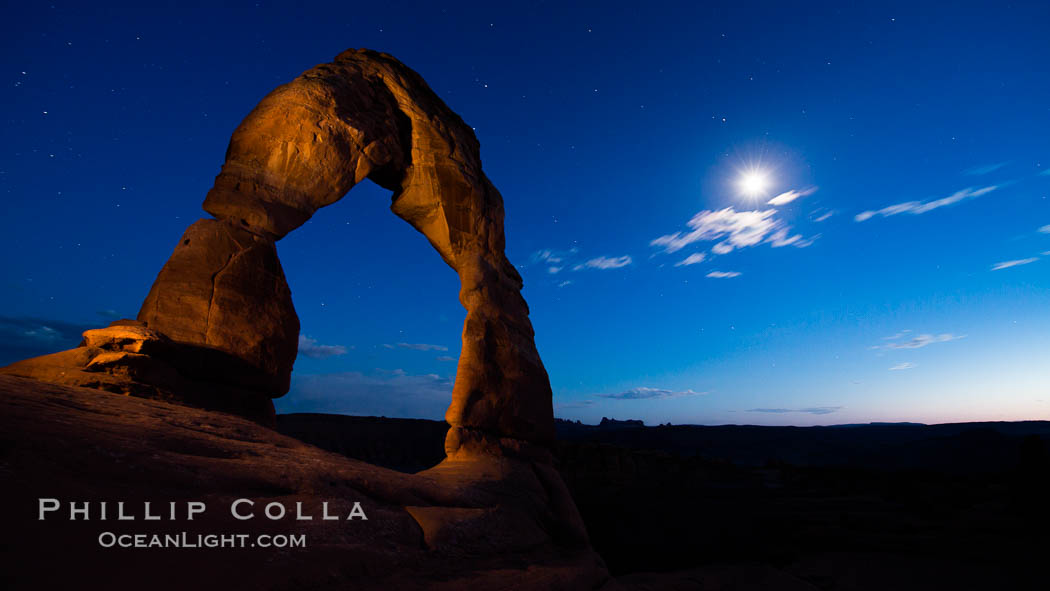 Delicate Arch and the Moon at Sunset.  The moon and clouds, with stars showing faintly in the sky, as sunset fades into night. (Note: this image was created before a ban on light-painting in Arches National Park was put into effect.  Light-painting is no longer permitted in Arches National Park). Utah, USA, natural history stock photograph, photo id 27860