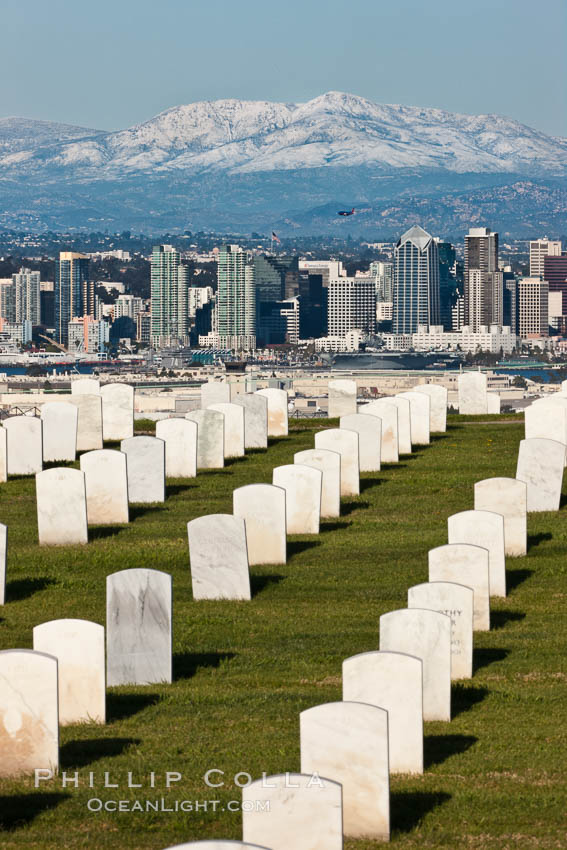 Tombstones at Fort Rosecrans National Cemetery, with downtown San Diego with snow-covered Mt. Laguna in the distance. California, USA, natural history stock photograph, photo id 26574