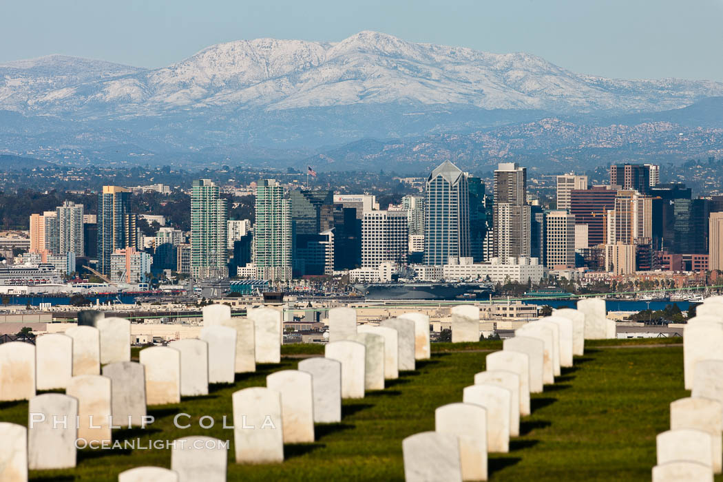 Tombstones at Fort Rosecrans National Cemetery, with downtown San Diego with snow-covered Mt. Laguna in the distance