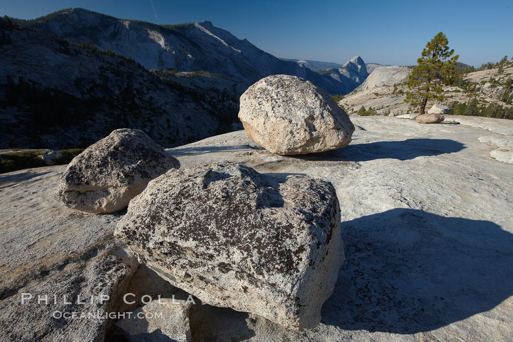 Glacial erratic boulders atop Olmsted Point, with the massive granite monoliths Half Dome and Clouds Rest in the background. Erratics are huge boulders left behind by the passing of glaciers which carved the granite surroundings into their present-day form. When the glaciers melt, any boulders and other geologic material that it was carrying are left in place, sometimes many miles from their original location, Yosemite National Park, California