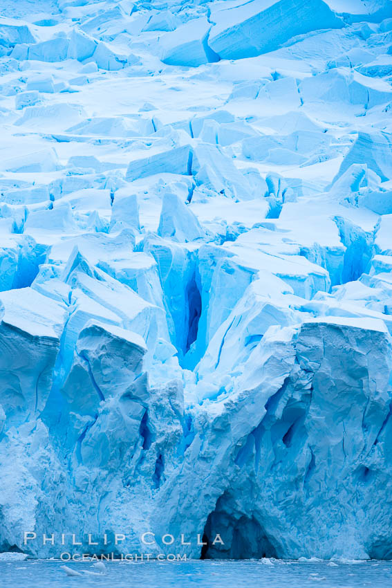 A glacier fractures and cracks, as the leading of a glacier fractures and cracks as it reaches the ocean.  The pieces will float away to become icebergs, Neko Harbor