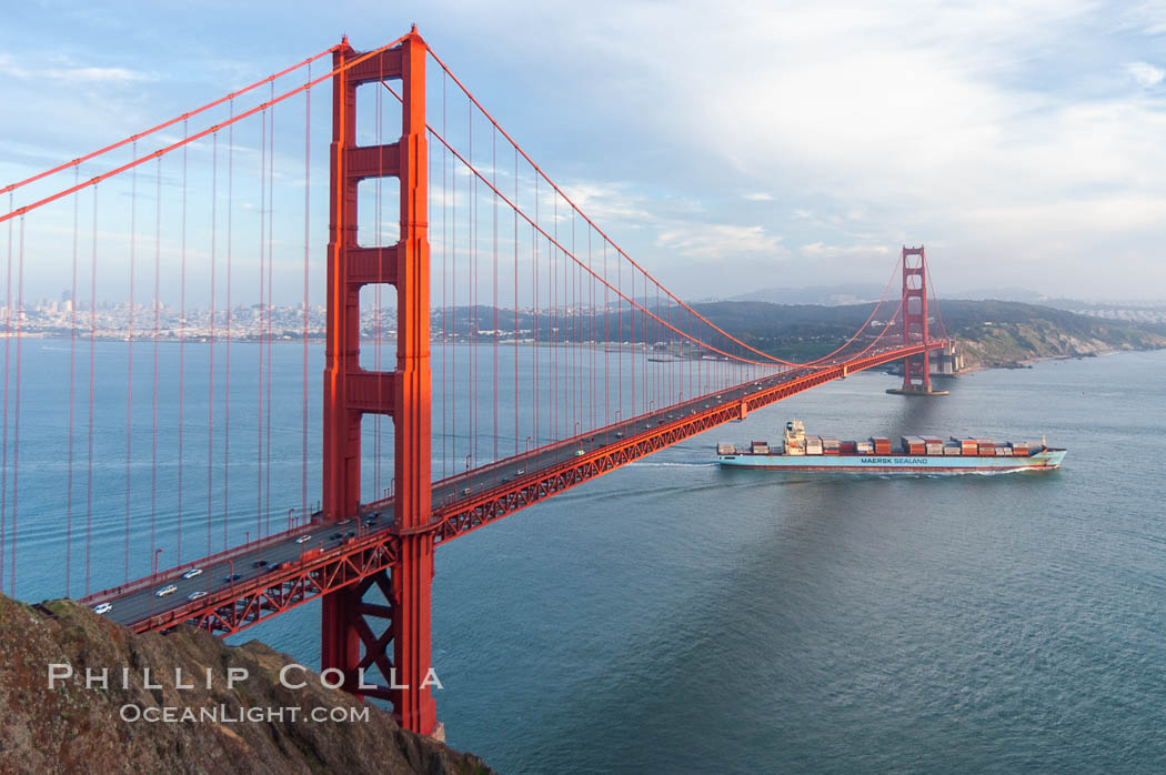 A container ship leaves San Francisco Bay, passing under the Golden Gate Bridge, viewed from the Marin Headlands with the city of San Francisco in the distance.  Late afternoon. California, USA, natural history stock photograph, photo id 09050