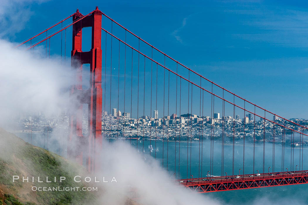 San Franciscos infamous summer fog overtakes the Golden Gate Bridge, viewed from the Marin Headlands with the city of San Francisco visible in the distance. California, USA, natural history stock photograph, photo id 09062