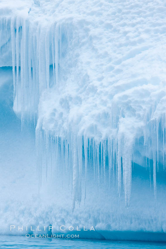 Icicles and melting ice, hanging from the edge of an blue iceberg.  Is this the result of climate change and global warming?. Brown Bluff, Antarctic Peninsula, Antarctica, natural history stock photograph, photo id 24857