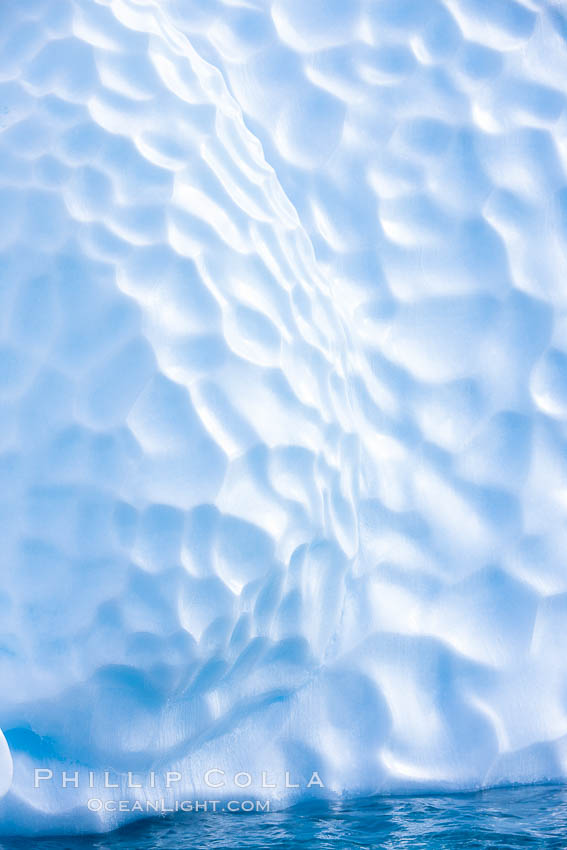 Iceberg with scalloped erosion.  The eroded indentations on this iceberg were melted when this portion of the iceberg was underwater.  As it melted, the iceberg grew topheavy, eventually flipping and exposing this interesting surface. Paulet Island, Antarctic Peninsula, Antarctica, natural history stock photograph, photo id 24893