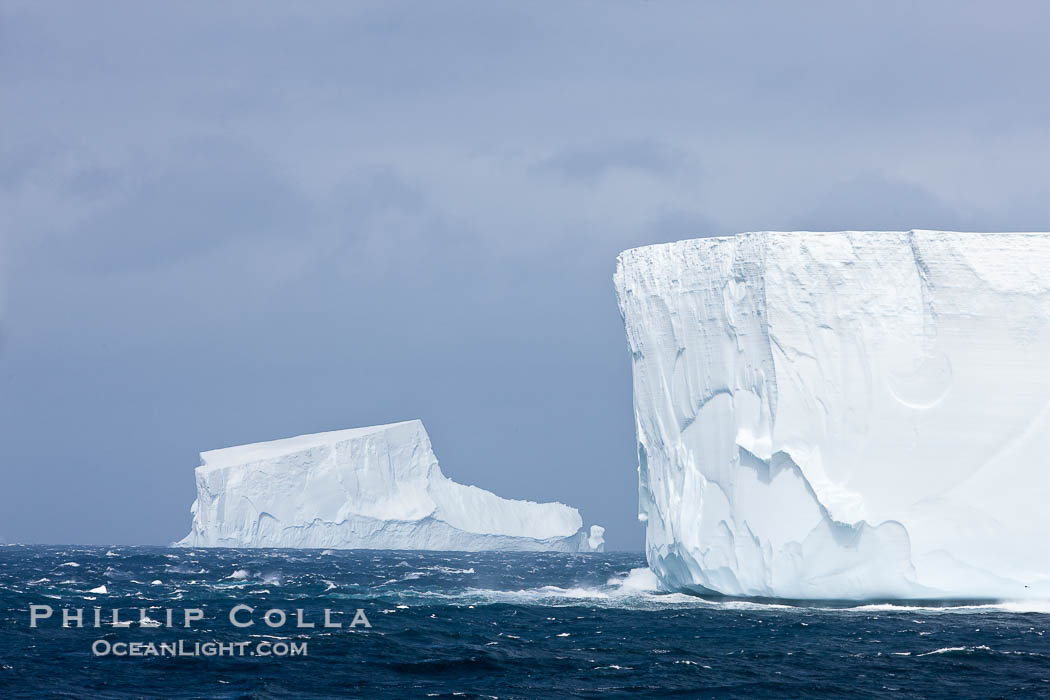 Iceberg (left) and tabular iceberg (right). Tabular icebergs can be dozens or hundreds of miles in size, have flat tops and sheer sides., natural history stock photograph, photo id 24937