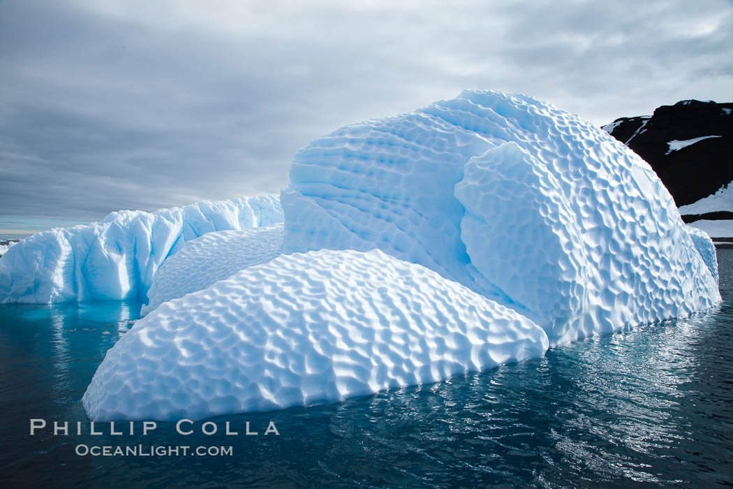 Iceberg with scalloped erosion.  The eroded indentations on this iceberg were melted when this portion of the iceberg was underwater.  As it melted, the iceberg grew topheavy, eventually flipping and exposing this interesting surface. Paulet Island, Antarctic Peninsula, Antarctica, natural history stock photograph, photo id 24789