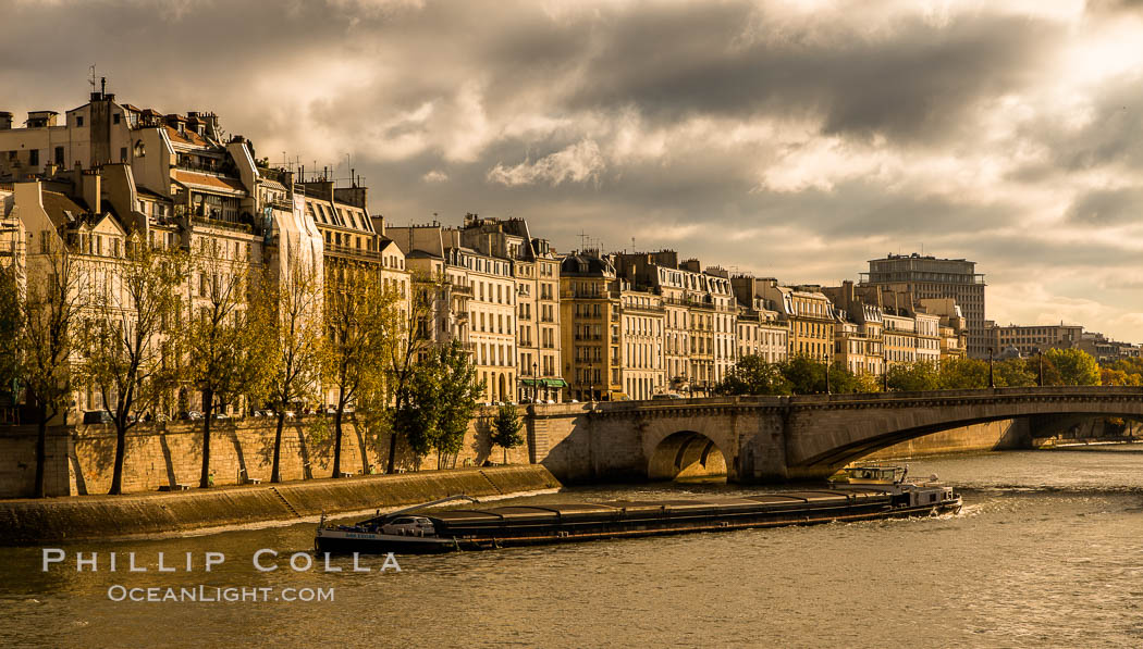 River Seine, barge and Ile Saint-Louis, sunrise, Paris. Ile Saint-Louis, is one of two natural islands in the Seine river, in Paris, France. The island is named after King Louis IX of France (Saint Louis). The island is connected to the rest of Paris by bridges to both banks of the river and by the Pont Saint Louis to the Ile de la Cite