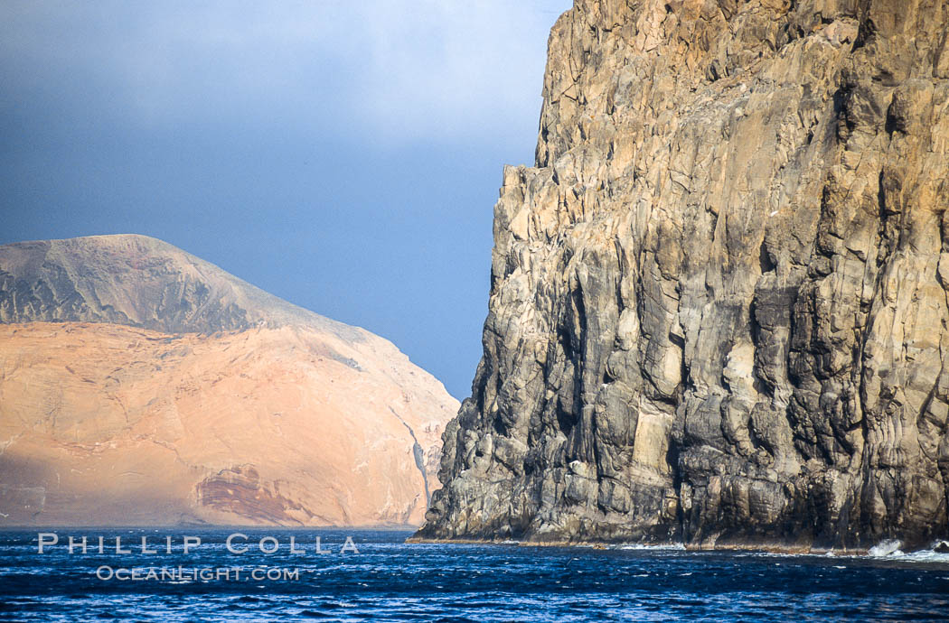 El Moro, a huge volcanic headland at the south end of Guadalupe Island, is seen here partially obscuring the more distant Isla Adentro.  Daybreak. Guadalupe Island (Isla Guadalupe), Baja California, Mexico, natural history stock photograph, photo id 09756