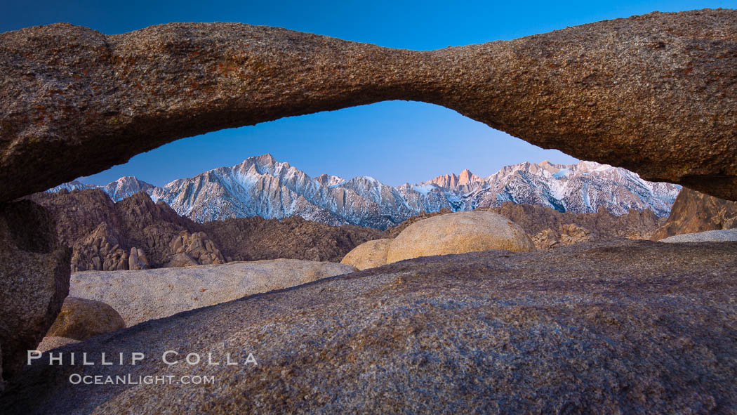 Mount Whitney and Lone Pine Peak are framed by Lathe Arch in the Alabama Hills at sunrise, California, Alabama Hills Recreational Area