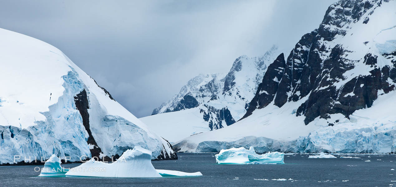 Lemaire Channel: mountains, sea, ice and clouds,Antarctica.  The Lemaire Channel, one of the most scenic places on the Antarctic Peninsula, is a straight 11 km long and only 1.6 km wide at its narrowest point