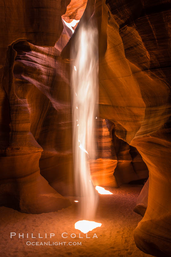 Light Beam in Upper Antelope Slot Canyon.  Thin shafts of light briefly penetrate the convoluted narrows of Upper Antelope Slot Canyon, sending piercing beams through the sandstone maze to the sand floor below. Navajo Tribal Lands, Page, Arizona, USA, natural history stock photograph, photo id 28566