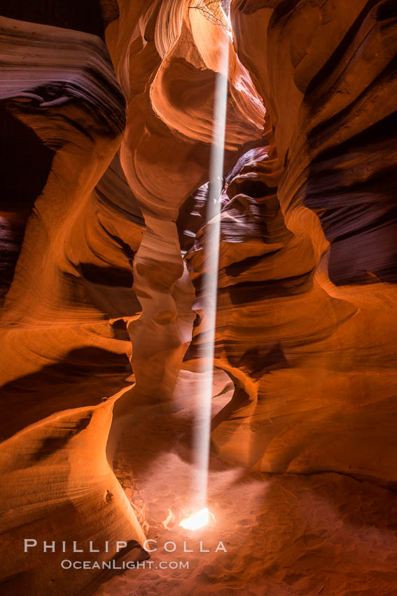 Light Beam in Upper Antelope Slot Canyon.  Thin shafts of light briefly penetrate the convoluted narrows of Upper Antelope Slot Canyon, sending piercing beams through the sandstone maze to the sand floor below, Navajo Tribal Lands, Page, Arizona