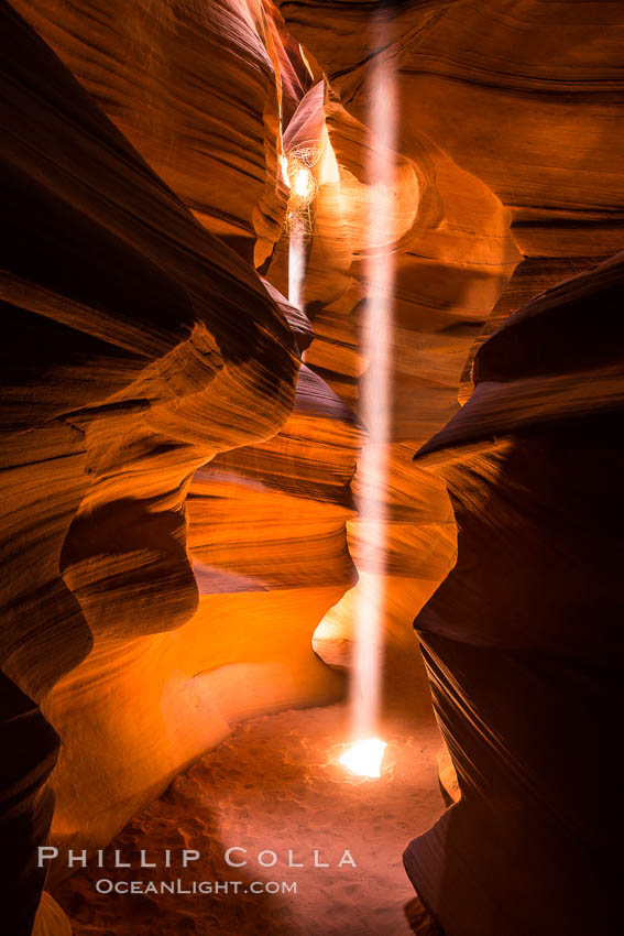 Light Beam in Upper Antelope Slot Canyon.  Thin shafts of light briefly penetrate the convoluted narrows of Upper Antelope Slot Canyon, sending piercing beams through the sandstone maze to the sand floor below. Navajo Tribal Lands, Page, Arizona, USA, natural history stock photograph, photo id 28571