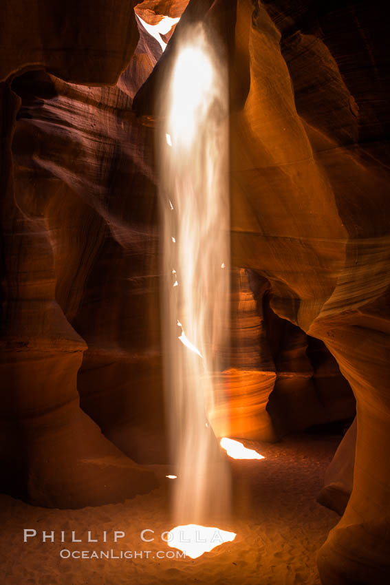 Light Beam in Upper Antelope Slot Canyon.  Thin shafts of light briefly penetrate the convoluted narrows of Upper Antelope Slot Canyon, sending piercing beams through the sandstone maze to the sand floor below. Navajo Tribal Lands, Page, Arizona, USA, natural history stock photograph, photo id 28565