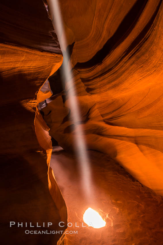 Light Beam in Upper Antelope Slot Canyon.  Thin shafts of light briefly penetrate the convoluted narrows of Upper Antelope Slot Canyon, sending piercing beams through the sandstone maze to the sand floor below. Navajo Tribal Lands, Page, Arizona, USA, natural history stock photograph, photo id 28569