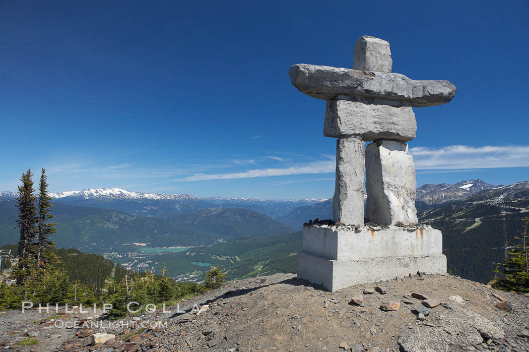 Ilanaaq, the logo of the 2010 Winter Olympics in Vancouver, is formed of stone in the Inukshuk-style of traditional Inuit sculpture.  Located near the Whistler mountain gondola station, overlooking Whistler Village and Green Lake in the distance. British Columbia, Canada, natural history stock photograph, photo id 21007