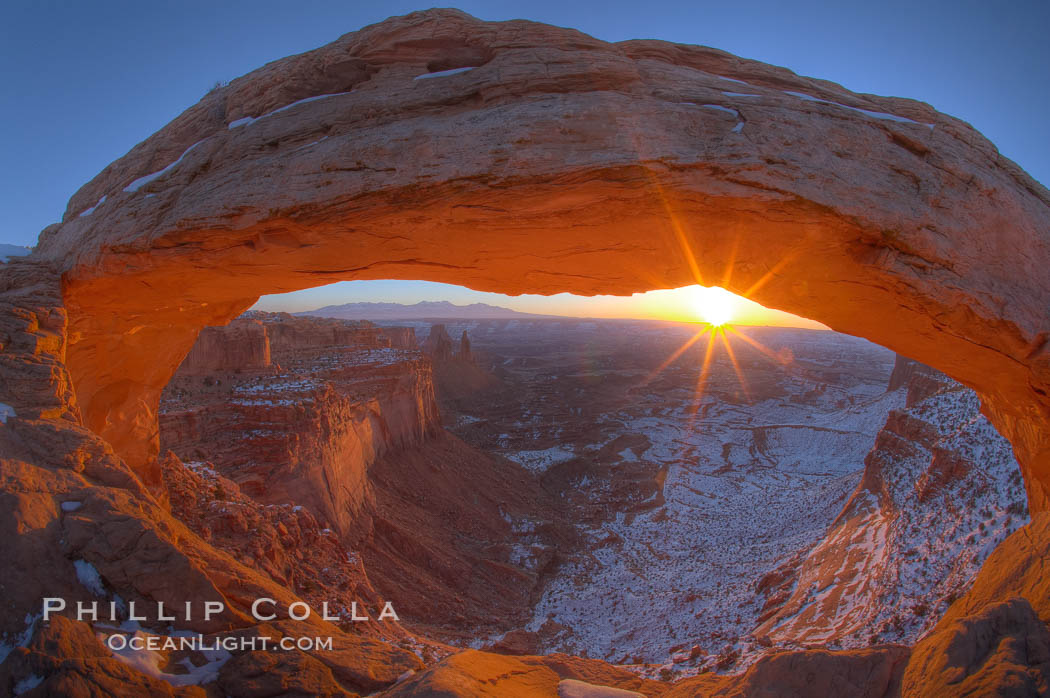 Mesa Arch spans 90 feet and stands at the edge of a mesa precipice thousands of feet above the Colorado River gorge. For a few moments at sunrise the underside of the arch glows dramatically red and orange. Island in the Sky, Canyonlands National Park, Utah, USA, natural history stock photograph, photo id 18041