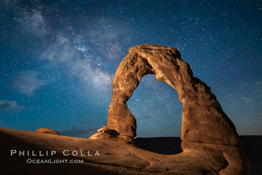 Milky Way arches over Delicate Arch, as stars cover the night sky. (Note: this image was created before a ban on light-painting in Arches National Park was put into effect.  Light-painting is no longer permitted in Arches National Park). Utah, USA, natural history stock photograph, photo id 27858
