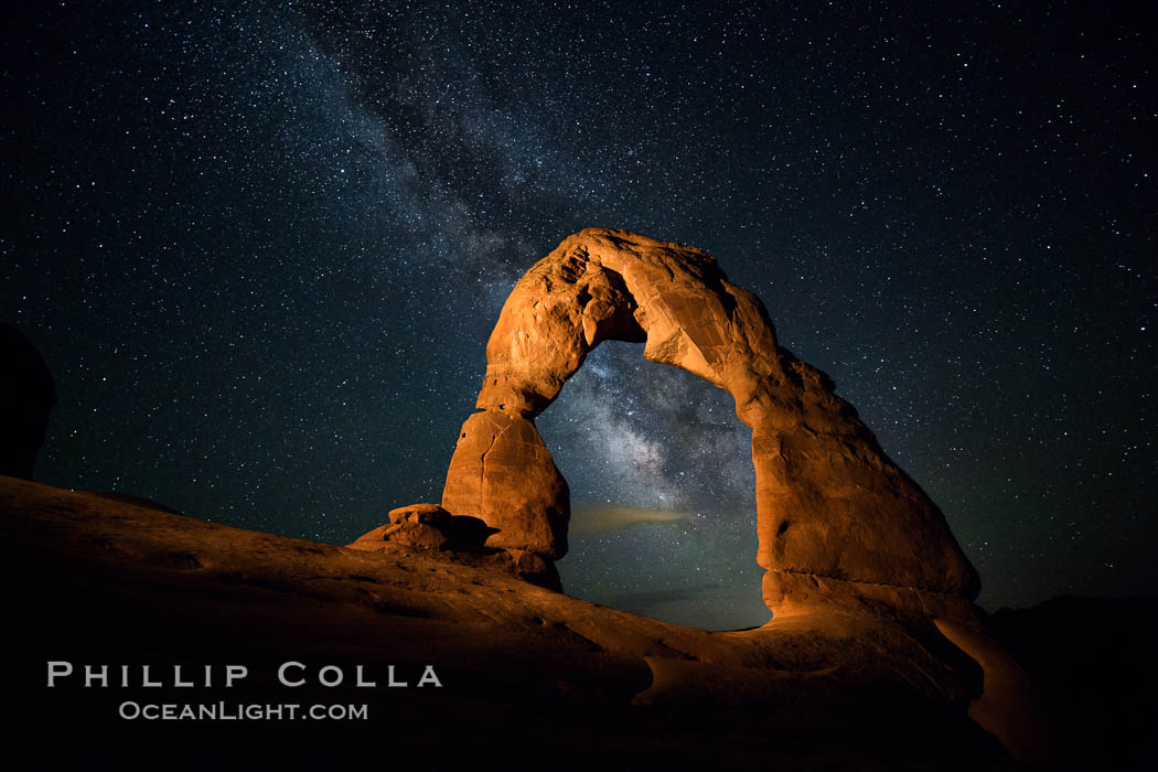 Milky Way arches over Delicate Arch, as stars cover the night sky. (Note: this image was created before a ban on light-painting in Arches National Park was put into effect.  Light-painting is no longer permitted in Arches National Park). Utah, USA, natural history stock photograph, photo id 27852