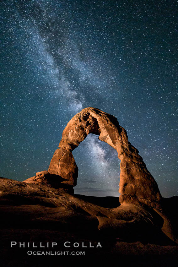 Milky Way arches over Delicate Arch, as stars cover the night sky. (Note: this image was created before a ban on light-painting in Arches National Park was put into effect.  Light-painting is no longer permitted in Arches National Park). Utah, USA, natural history stock photograph, photo id 27851