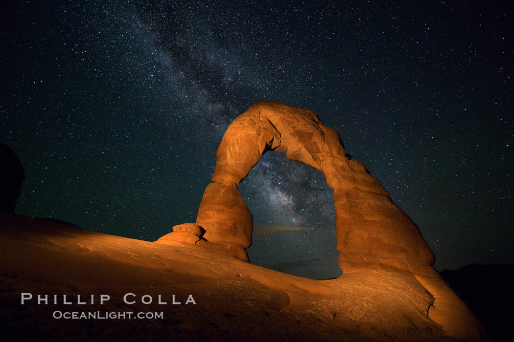 Milky Way arches over Delicate Arch, as stars cover the night sky. (Note: this image was created before a ban on light-painting in Arches National Park was put into effect.  Light-painting is no longer permitted in Arches National Park). Utah, USA, natural history stock photograph, photo id 27853