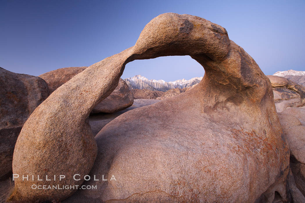 Mobius Arch at sunrise, with Mount Whitney (the tallest peak in the continental United States), Lone Pine Peak and snow-covered Sierra Nevada Range framed within the arch. Mobius Arch is a 17-foot-wide natural rock arch in the scenic Alabama Hills Recreational Area near Lone Pine, California