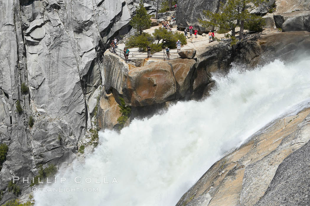 The brink of Nevada Falls, with hikers visible at the precipice. Nevada Falls marks where the Merced River plummets almost 600 through a joint in the Little Yosemite Valley, shooting out from a sheer granite cliff and then down to a boulder pile far below. Yosemite National Park, California, USA, natural history stock photograph, photo id 16121