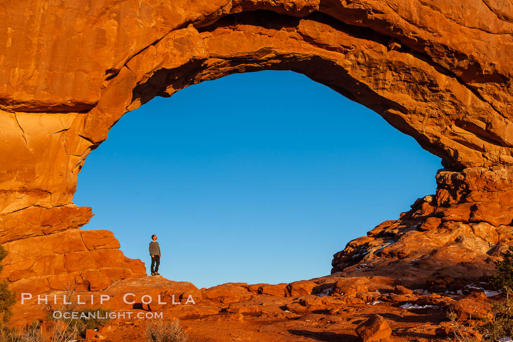 Hiker in North Window, sunset, western face.  North Window is a natural sandstone arch 90 feet wide and 48 feet high. Arches National Park, Utah, USA, natural history stock photograph, photo id 18160
