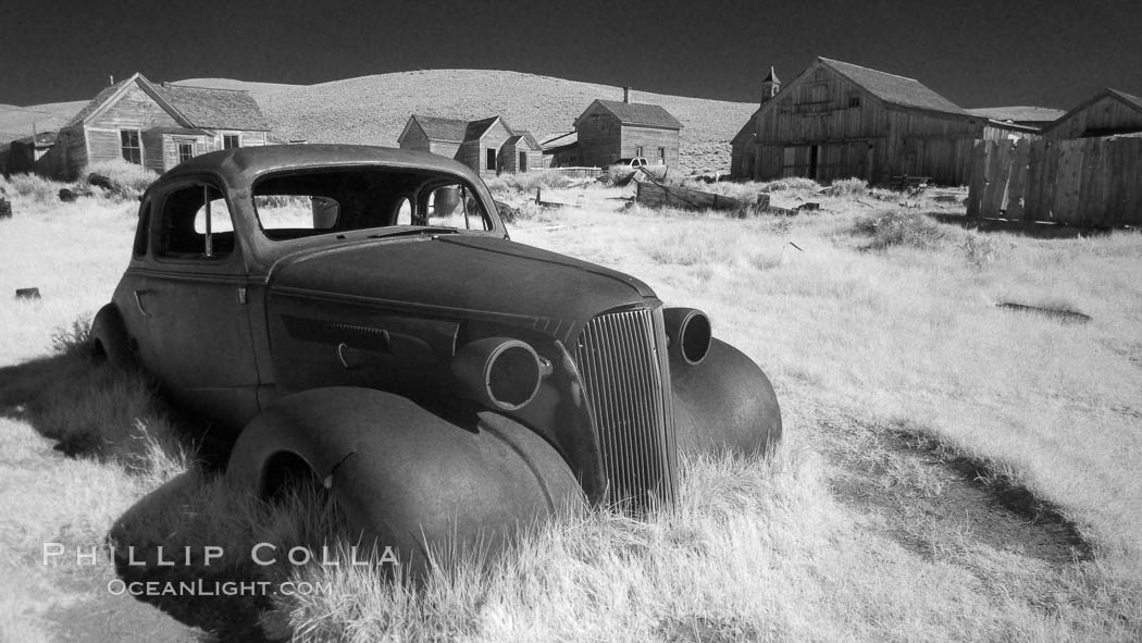 Old car lying in dirt field, Bodie State Historical Park, California