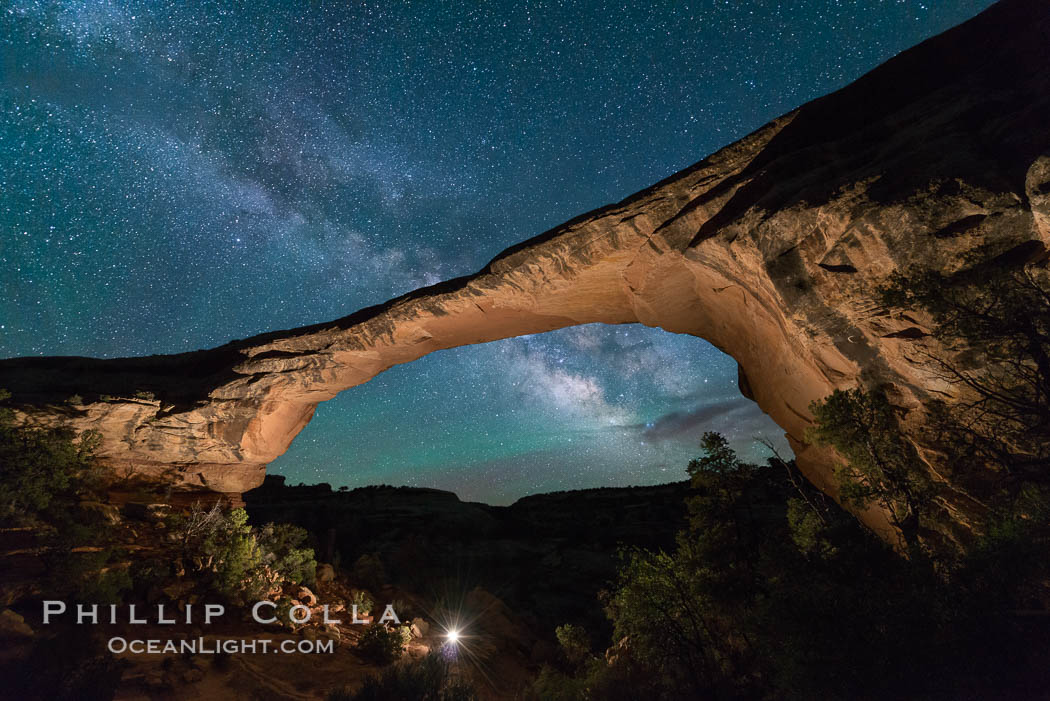 Owachomo Bridge and Milky Way.  Owachomo Bridge, a natural stone bridge standing 106' high and spanning 130' wide,stretches across a canyon with the Milky Way crossing the night sky, Natural Bridges National Monument, Utah