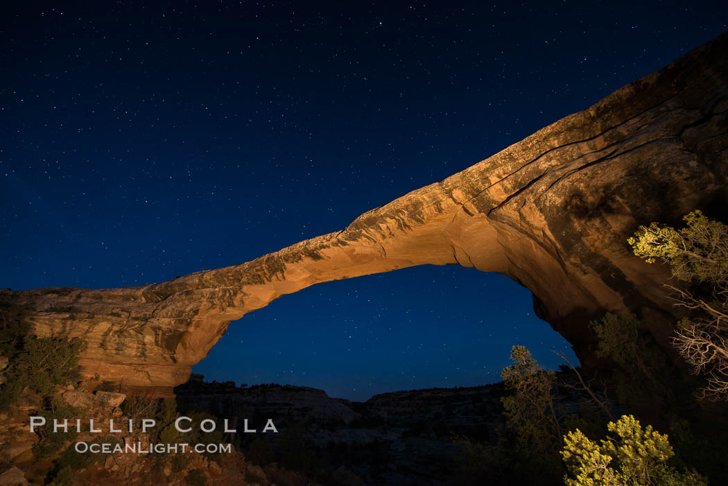 Owachomo Bridge at sunset, stars and blue sky.  Owachomo Bridge, a natural stone bridge standing 106' high and spanning 130' wide,stretches across a canyon with the Milky Way crossing the night sky. Natural Bridges National Monument, Utah, USA, natural history stock photograph, photo id 28546
