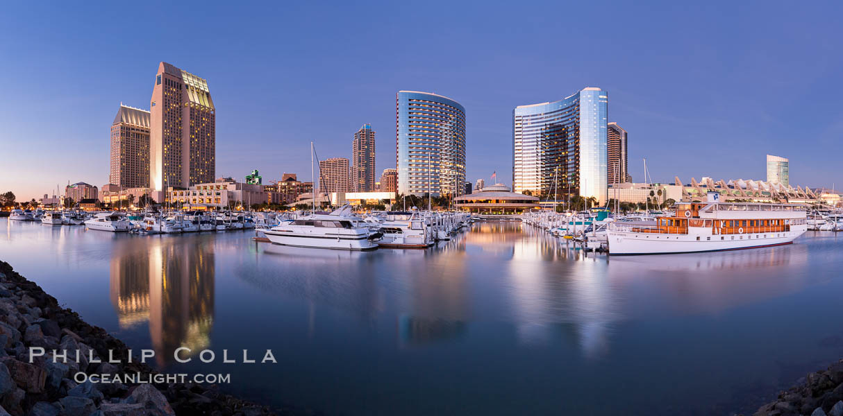 Panoramic photo of San Diego embarcadero, showing the San Diego Marriott Hotel and Marina (center), Roy's Restaurant (center) and Manchester Grand Hyatt Hotel (left) viewed from the San Diego Embarcadero Marine Park