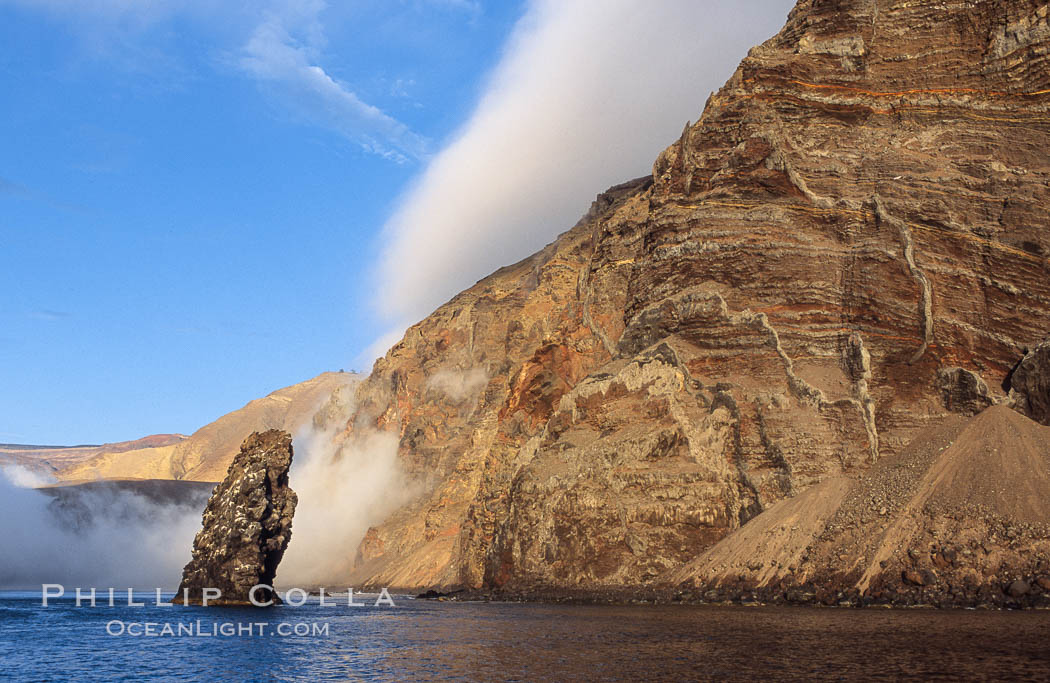 Pilot Rock (Roca Pilote), a undersea spire which extends 100 out of the water, stands below the immense seacliffs and morning clouds at the north end of Guadalupe Island (Isla Guadalupe), far offshore of the Baja California peninsula. Mexico, natural history stock photograph, photo id 09748
