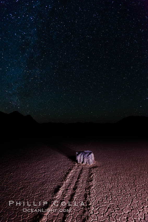Racetrack sailing stone and stars at night. A sliding rock of the Racetrack Playa. The sliding rocks, or sailing stones, move across the mud flats of the Racetrack Playa, leaving trails behind in the mud. The explanation for their movement is not known with certainty, but many believe wind pushes the rocks over wet and perhaps icy mud in winter. Death Valley National Park, California, USA, natural history stock photograph, photo id 27669