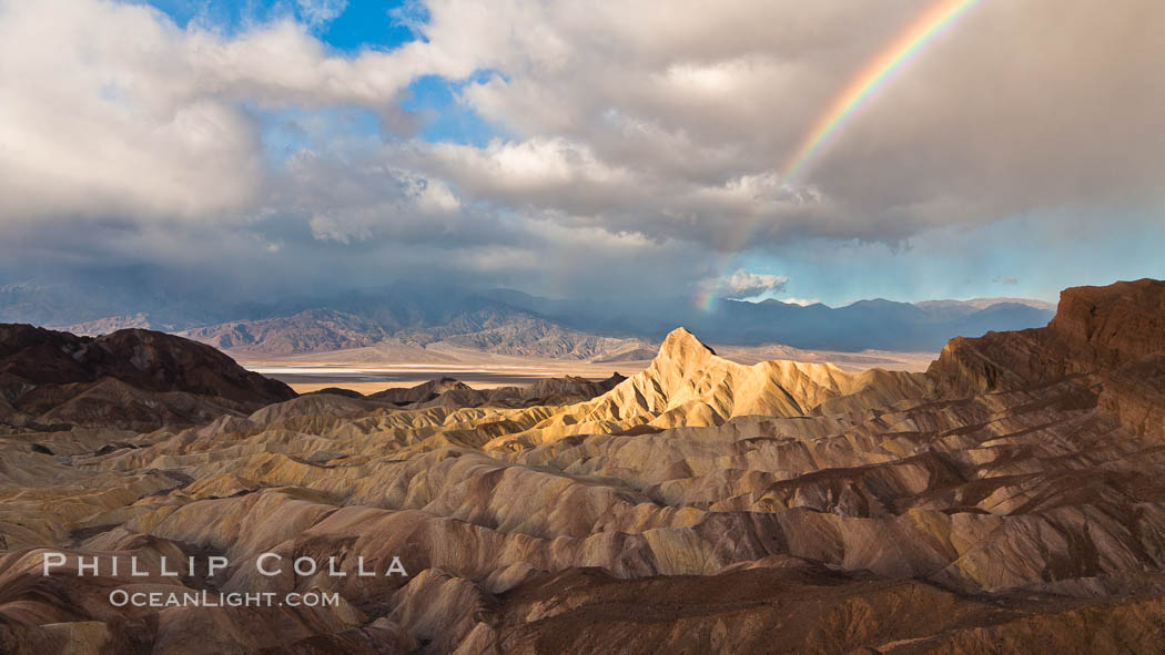 Rainbow and clearing storm clouds, sunrise light on Manly Beacon, Zabriskie Point, Death Valley National Park, California