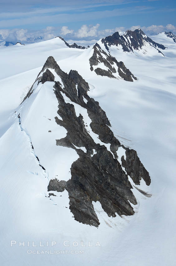 The Kenai Mountains rise above thick ice sheets and the Harding Icefield which is one of the largest icefields in Alaska and gives rise to over 30 glaciers. Kenai Range, Kenai Fjords National Park, USA, natural history stock photograph, photo id 19016