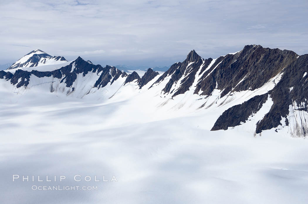 The Kenai Mountains rise above thick ice sheets and the Harding Icefield which is one of the largest icefields in Alaska and gives rise to over 30 glaciers. Kenai Fjords National Park, USA, natural history stock photograph, photo id 19024